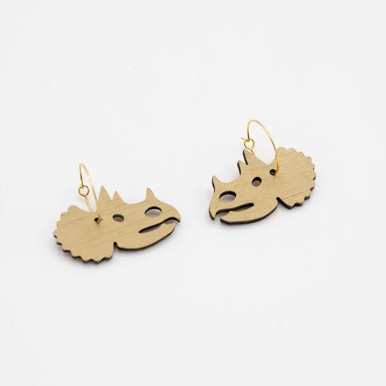 Pair of natural wood triceratops-head-shaped earrings on a white background