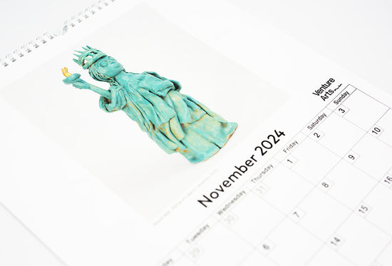 Load image into Gallery viewer, A close up of the November page of the calendar featuring a ceramic reproduction of the statue of liberty
