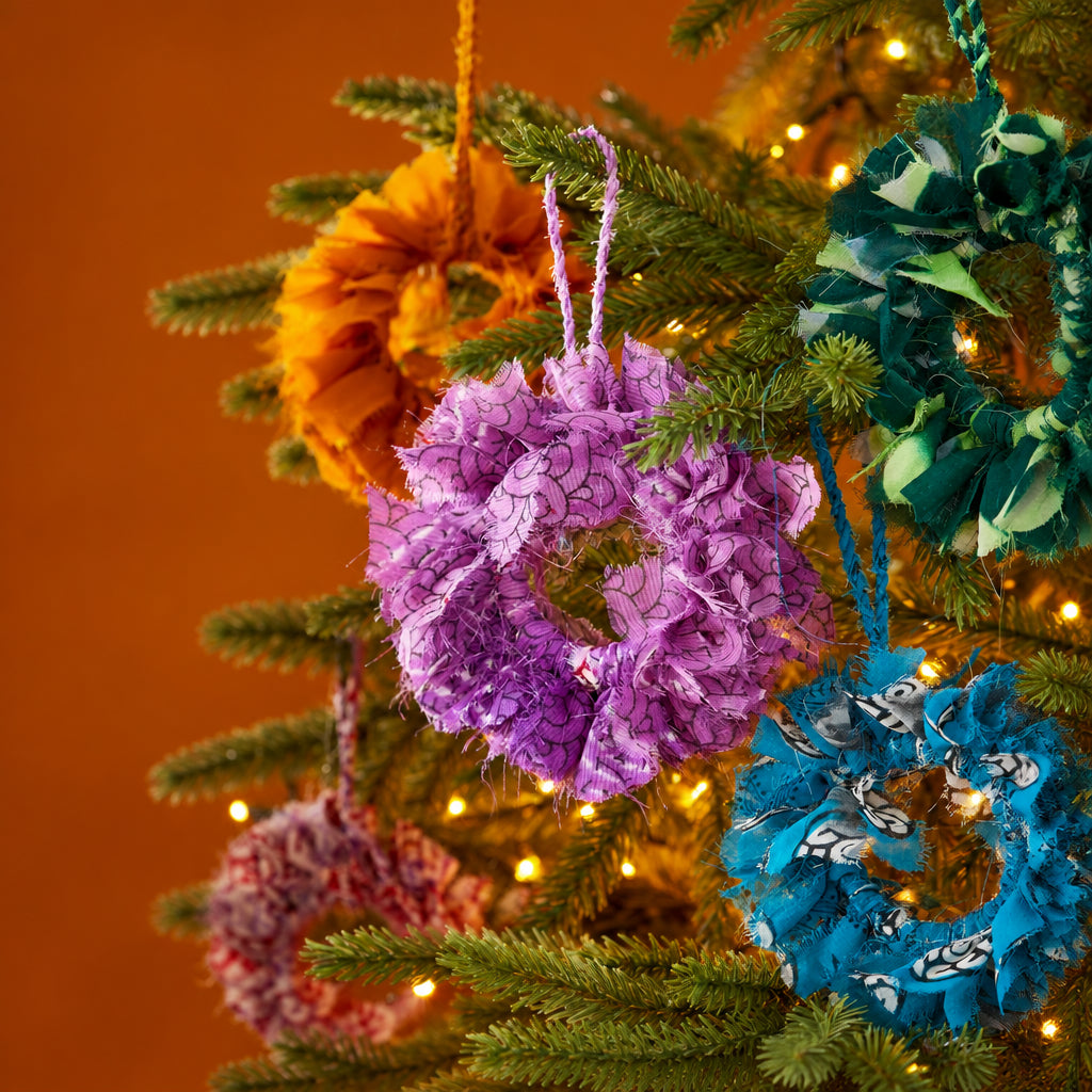 Handcrafted mini wreath made from recycled sari fabric in assorted colours and textures, finished with a hanging loop for festive decoration.