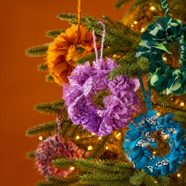 Handcrafted mini wreath made from recycled sari fabric in assorted colours and textures, finished with a hanging loop for festive decoration.