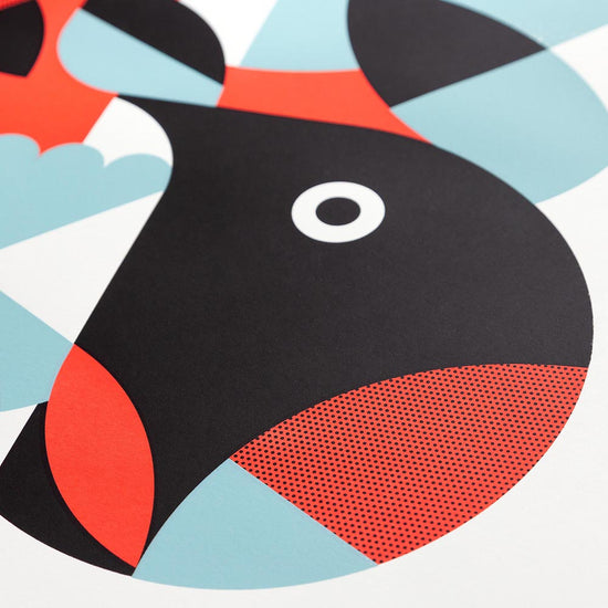 Close up view of the abstract bird design with black, red, and blue shapes on a white background