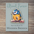 Wooden brooch with a blue tit motif. The brooch is on a grey backing card with Ellwood Parker branding.