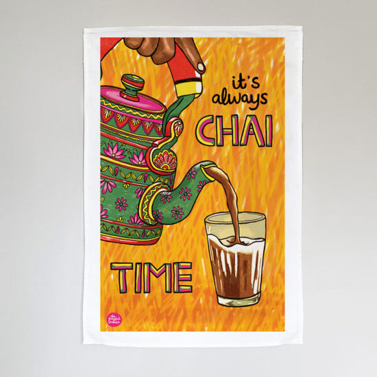 A colourful tea towel with a vibrant illustration of a hand pouring chai from a decorated teapot into a glass and the words 'it's always CHAI TIME'.