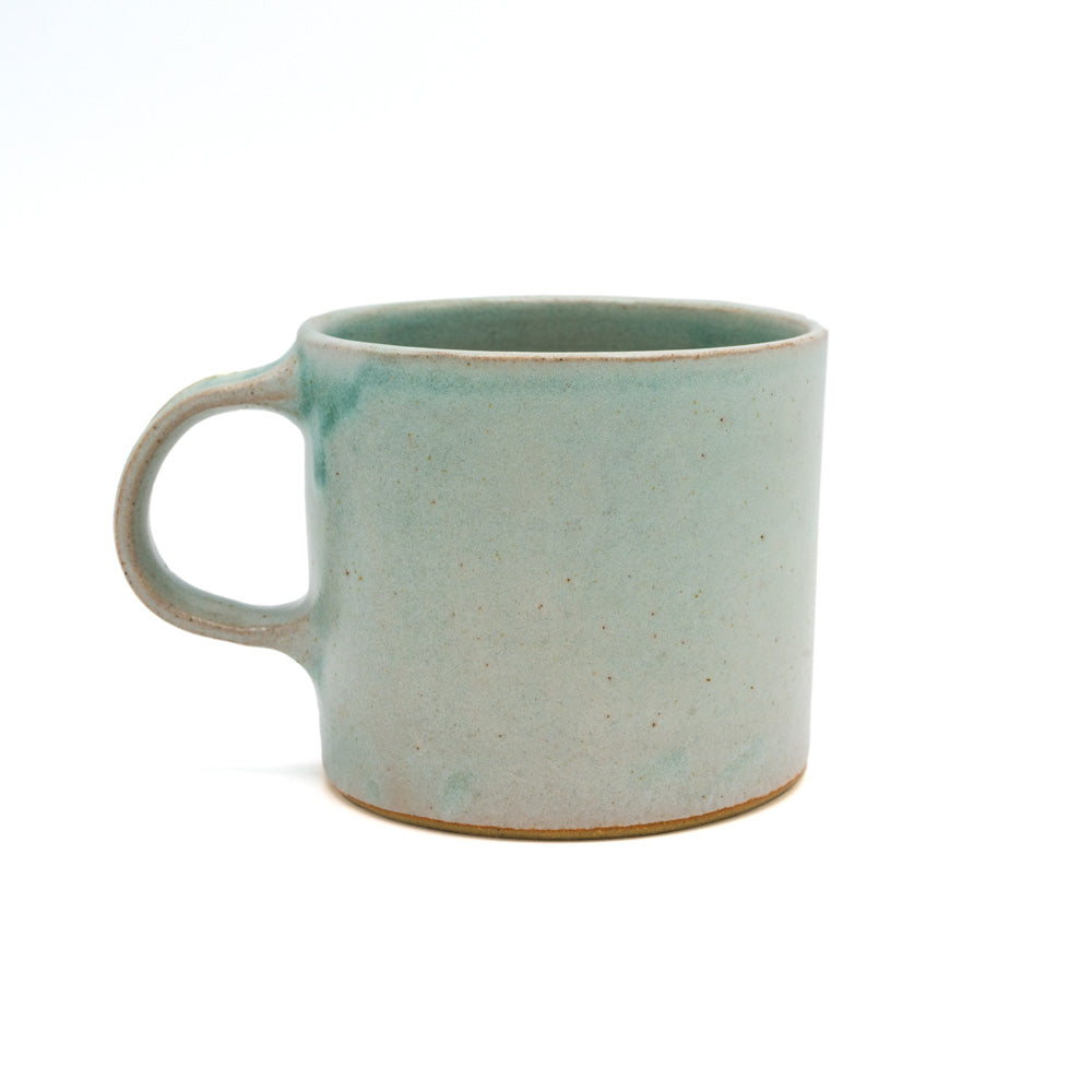 Blue glazed ceramic mug photographed in front of a white background.