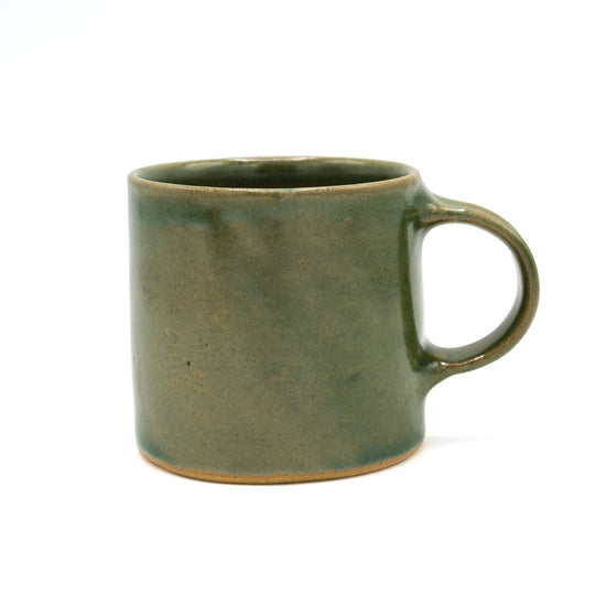 Green glazed ceramic mug photographed in front of a white background.