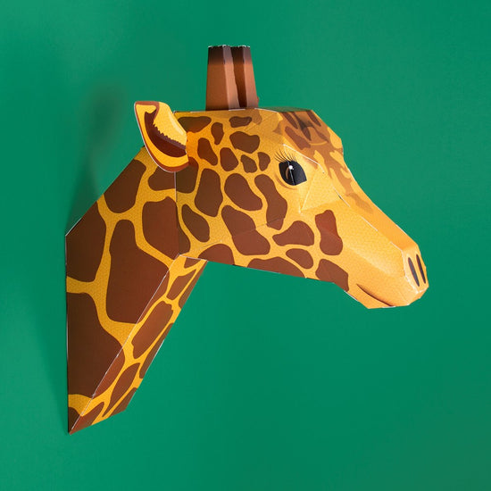 Side view of the assembled giraffe head on a deep green background.