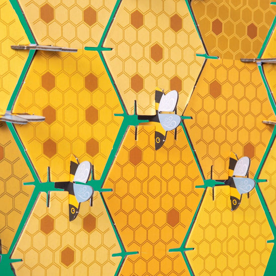 Close up of a straightside of the assembled beehive with the bees holding the hexagonal pieces of honeycomb together in a uniform pattern.