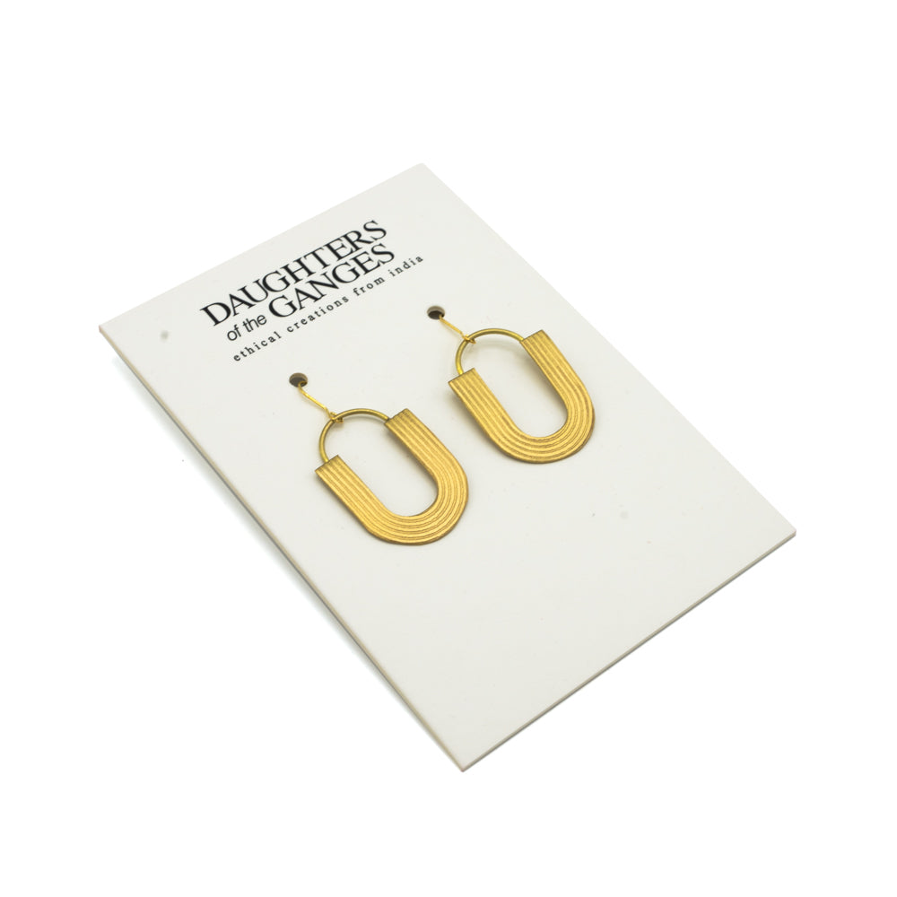 Gold U shaped earrings photographed on Daughters of the Ganges branded backing card against a white background.