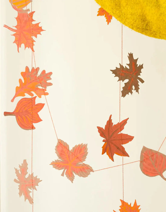 Decorative string with orange and brown leaves on a light background
