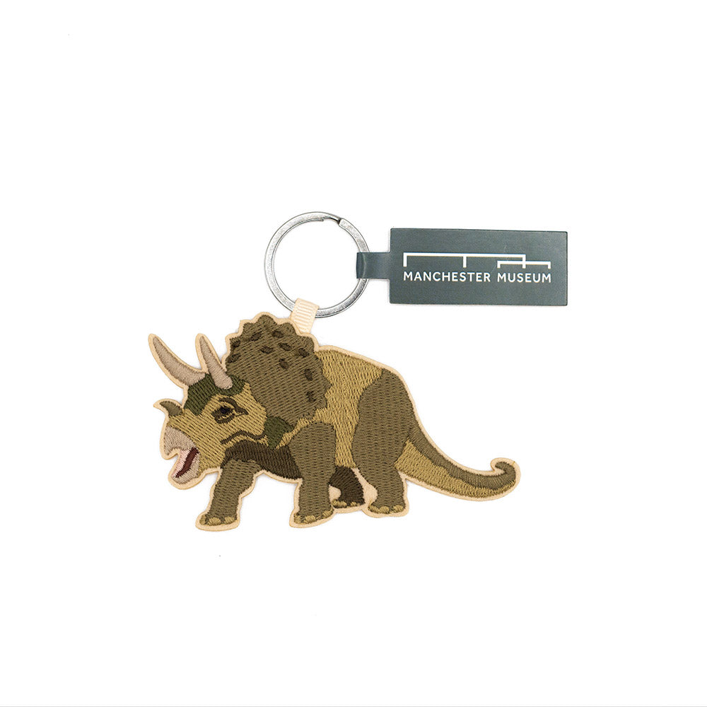 Dinosaur keychain with Manchester Museum tag on a white background