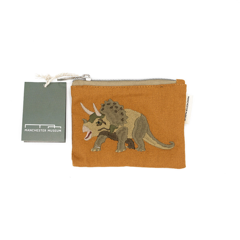 Orange pouch with dinosaur design and Manchester Museum tag on a white background