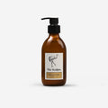 An amber glass pump bottle with a black dispenser cap and a cream label featuring a black flamingo illustration and the text 'The Sculpts. Honeycomb & Hand Lotion'.