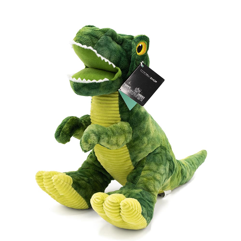 Green fabric toy in the shape of a T-Rex pin front of a white background.