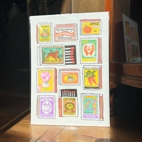 A colourful print showing lots of different matchboxes with cool pictures and names on them, like "Three Mangoes" and "Palm & Tiger".