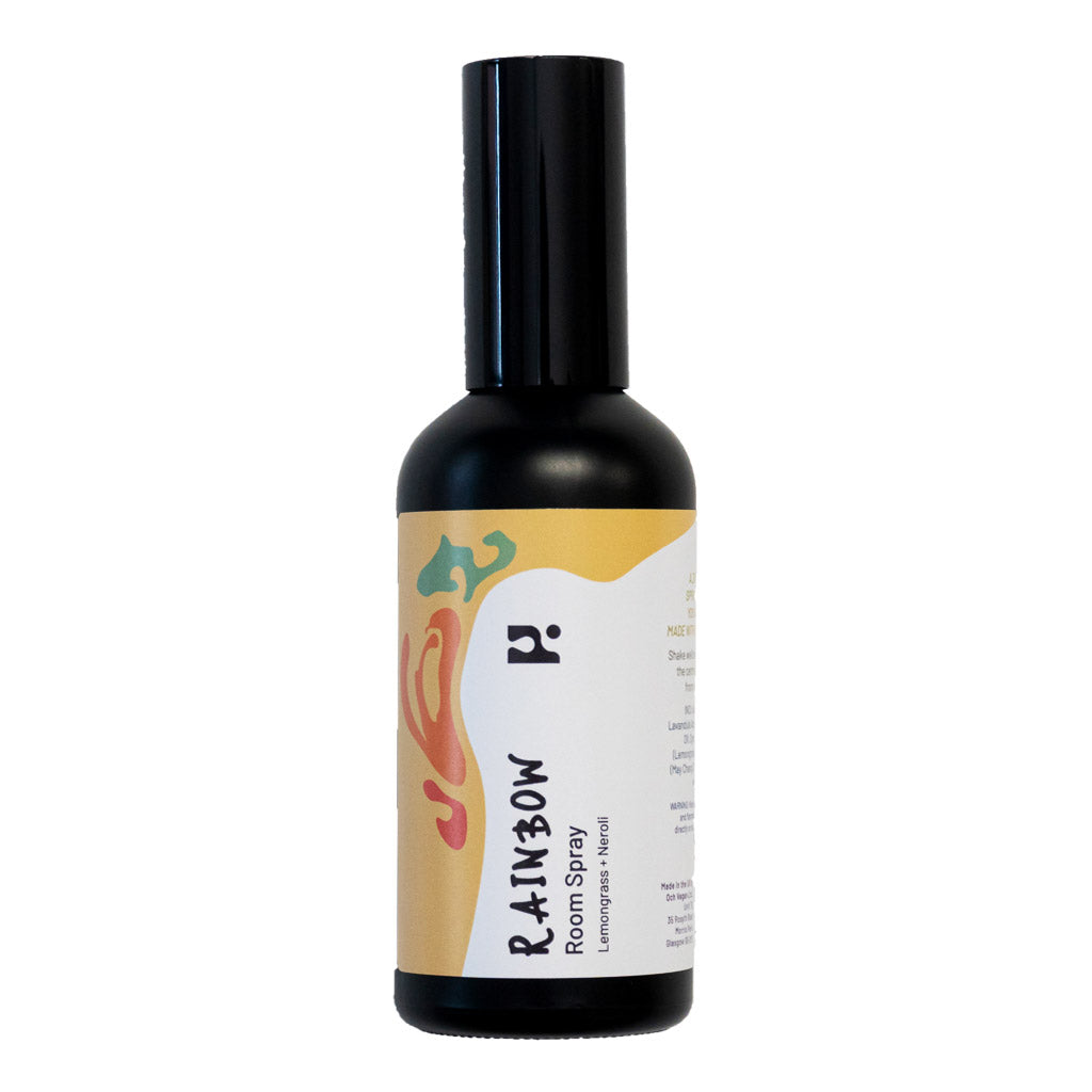 Black room spray bottle with colourful label, isolated against a white background.