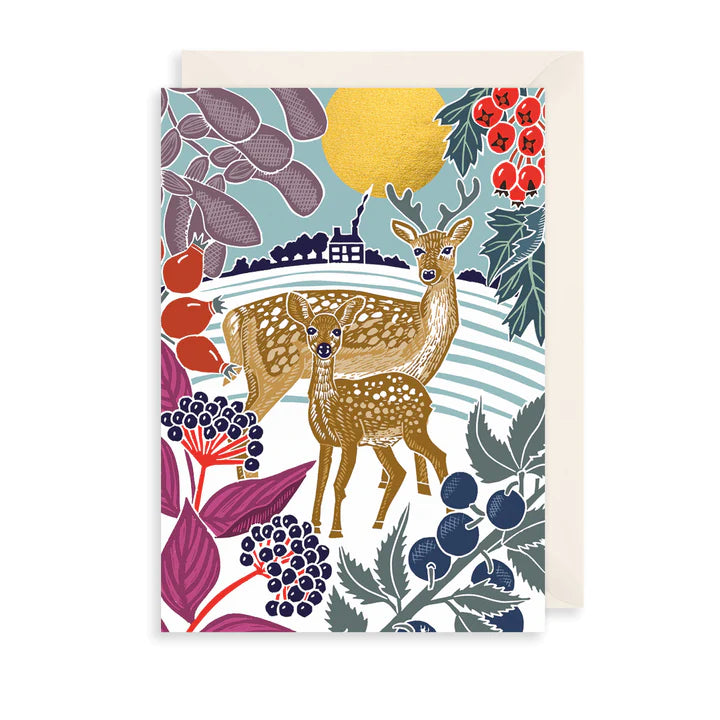 Card with beige envelope against white background. Card features an illustration of two deer in a winter scene.