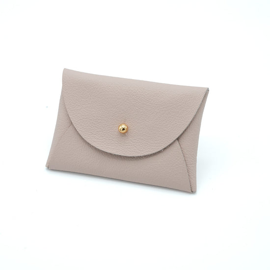 Rectangular leather purse in pale pink with gold button.