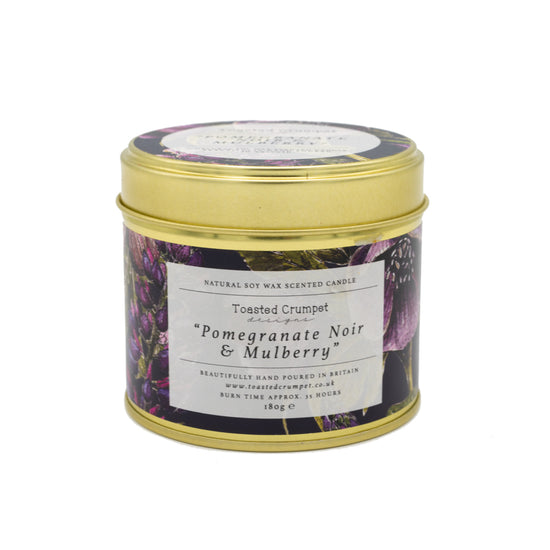 Candle in gold tin with purple floral pattened design label - white background. 