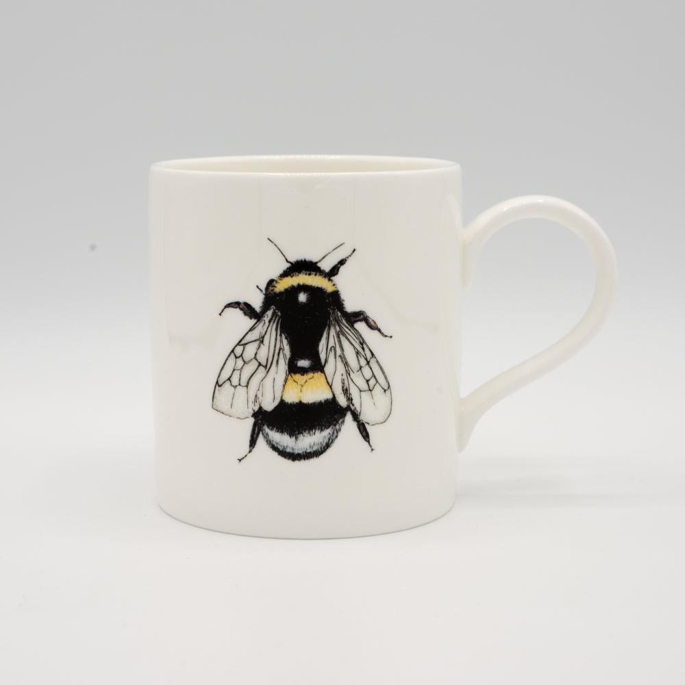 White mug with a picture of a bee on it.  Photographed against white background.