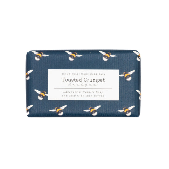 Rectangular soap wrapped in bee-patterned packaging with a label by Toasted Crumpet.  Photographed against a white background.