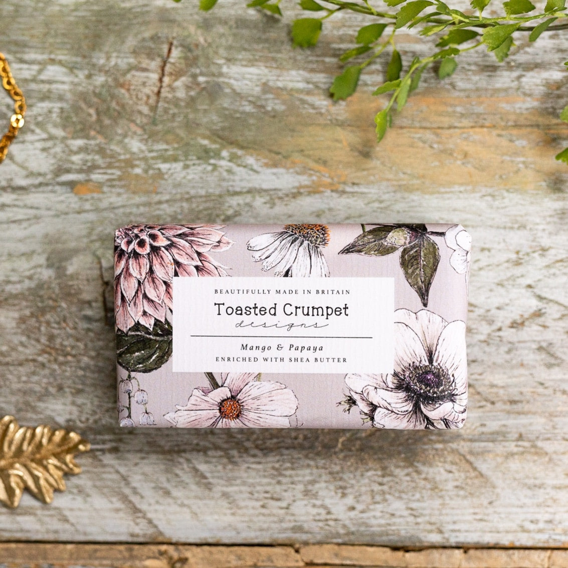 Soap with floral Toasted Crumpet packaging on a grey wooden surface