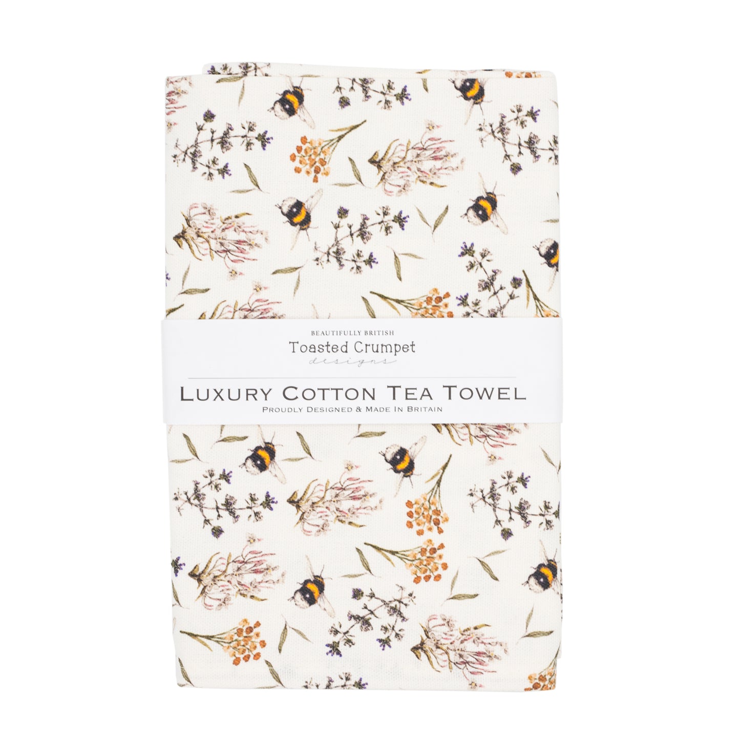Tea towel with bee and floral pattern folded into a rectangular shape with a white belly band with Toasted Crumpet branding. Photographed against a white background.