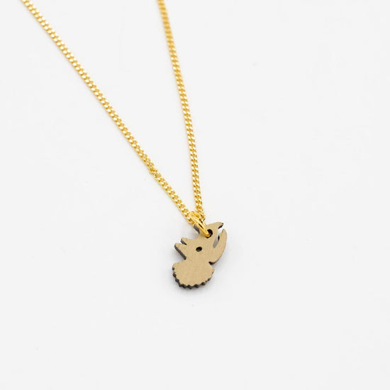 Gold chain necklace with a green triceratops head-shaped pendant on a white background