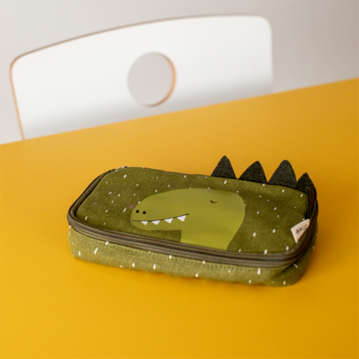 Green rectangular pencil case with an illustration of a dinosaur on a yellow table top