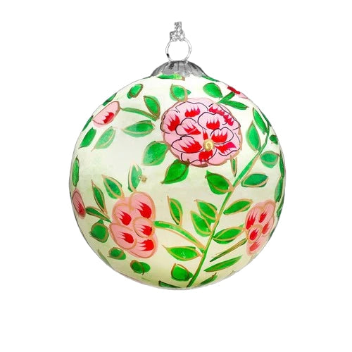 A round, cream-coloured Christmas ornament decorated with pink roses, green leaves, and gold accents.