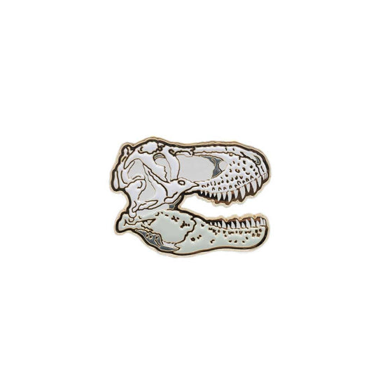 The white and gold t-rex skull pin against a white background.