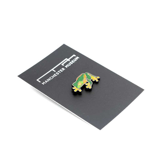 The green, orange and yellow Sylvias leaf frog pin on the black backing card and seen at a slight angle.