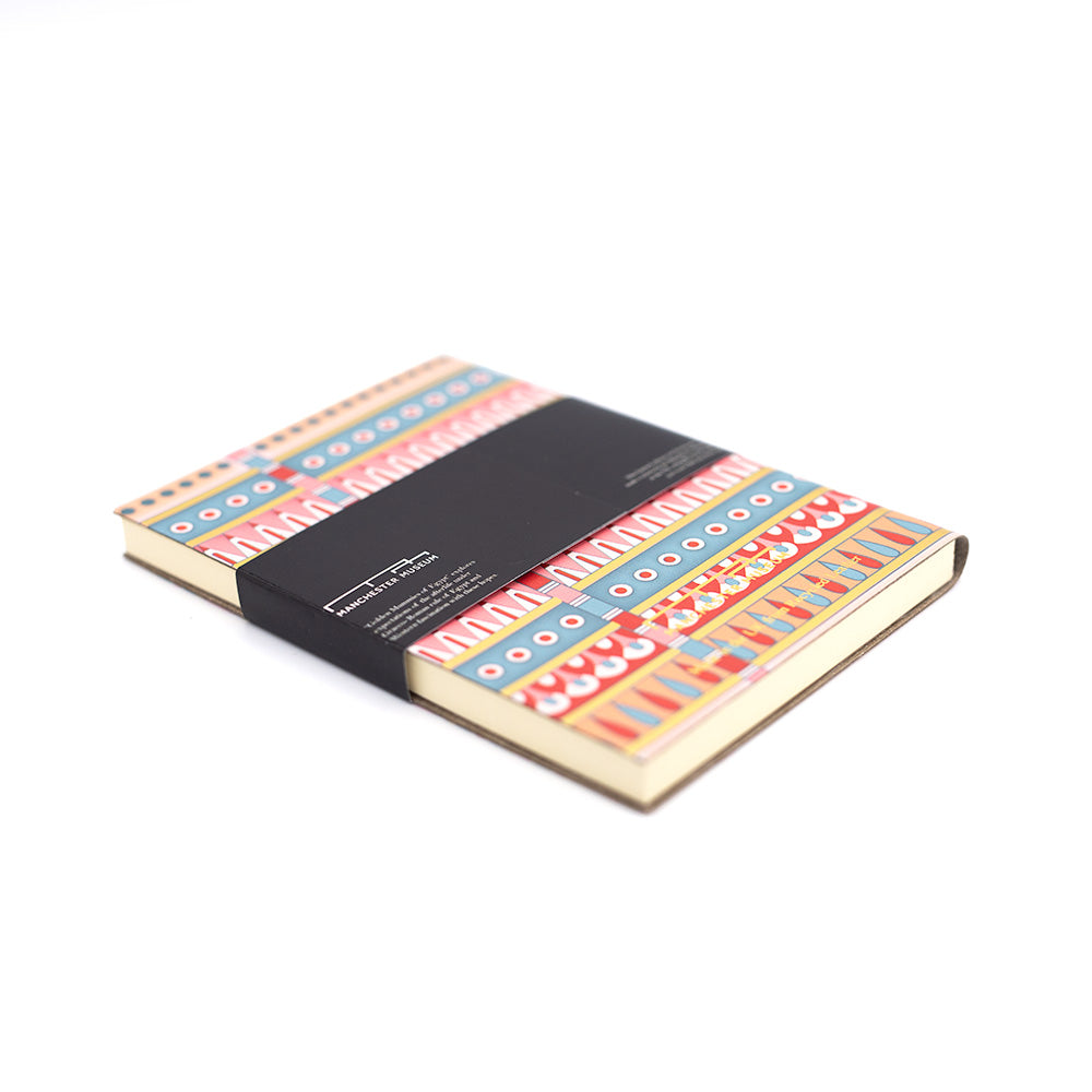 Side slightly angled back view of the patterned notebook with the black belly band with Manchester Museum branding. 