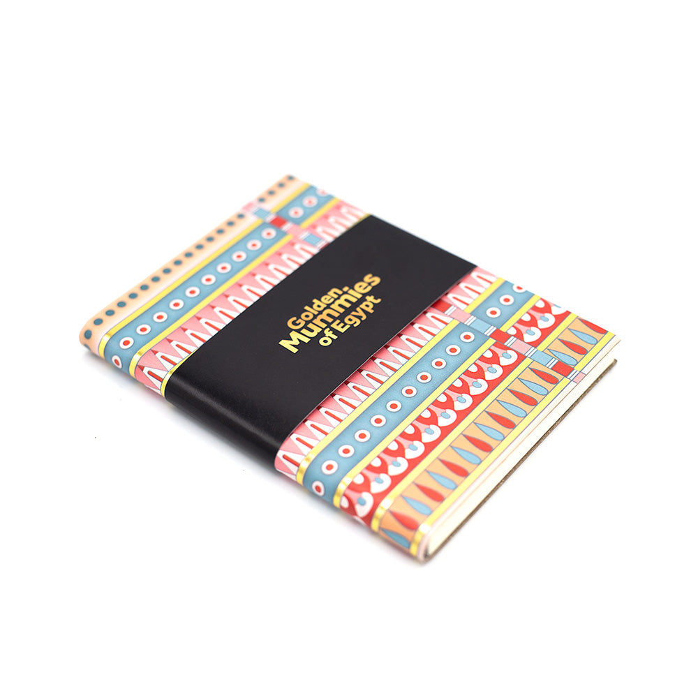 Side slightly angled view of the patterned notebook with the black belly band with text reading, Golden Mummies of Egypt.