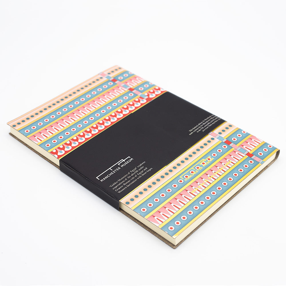 Rear angled view of the patterned notebook with the black belly band and Manchester Museum branding.