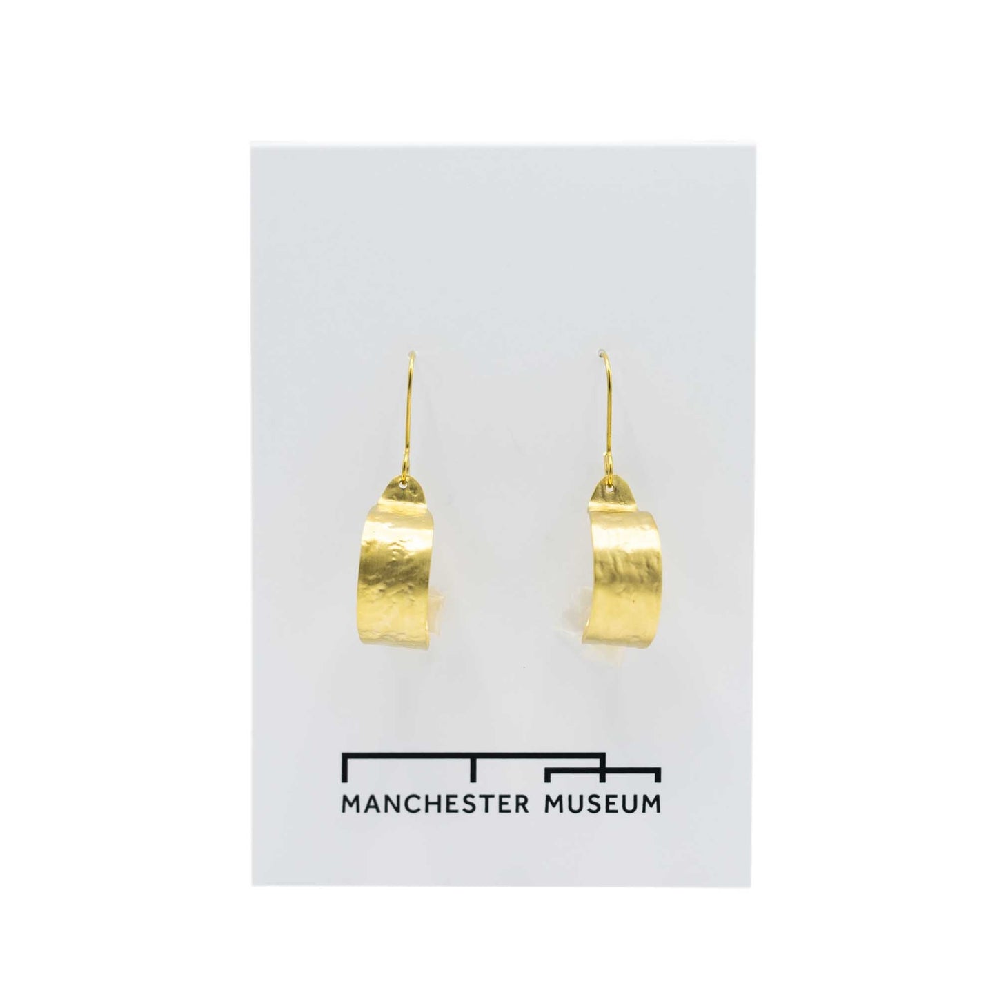 Hammered brass hoop earrings on a white, museum branded backing card.