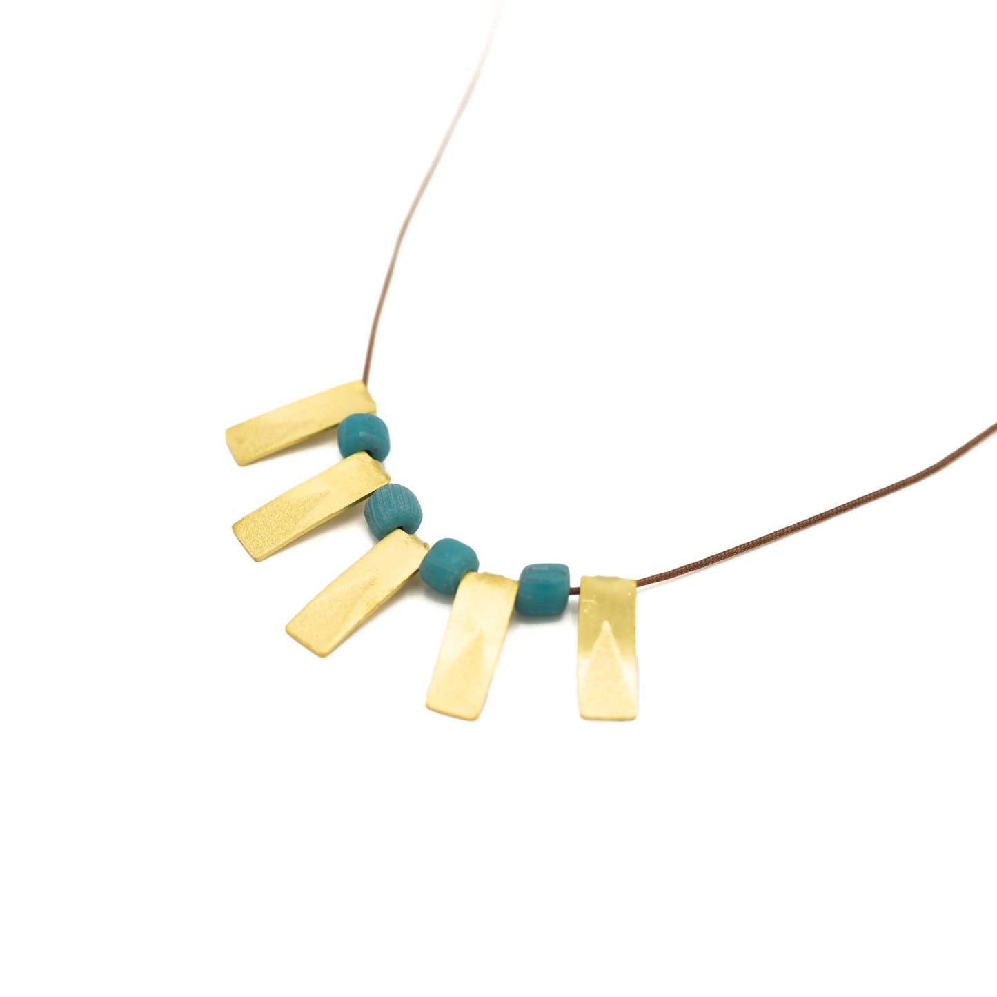 Five brass rectangular pendants with a turquoise glass bead between each. Brown string and presented at an angle against a white background.