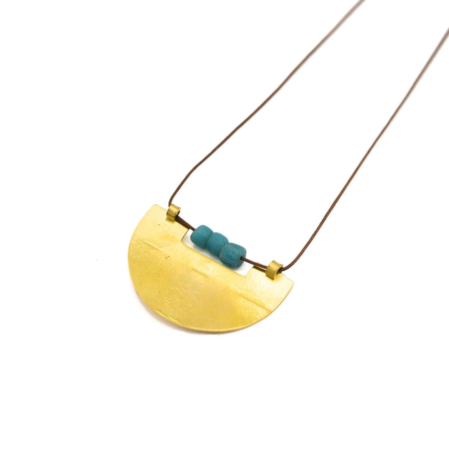 Brass semi-circle pendant with a cutout on the flat top to accommodate three turquoise glass beads. Brown string and presented at an angle against a white background.