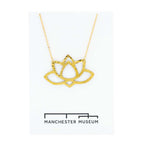 Brass lotus statement necklace draped over the museum branded white card that is part of the sustainable packaging.