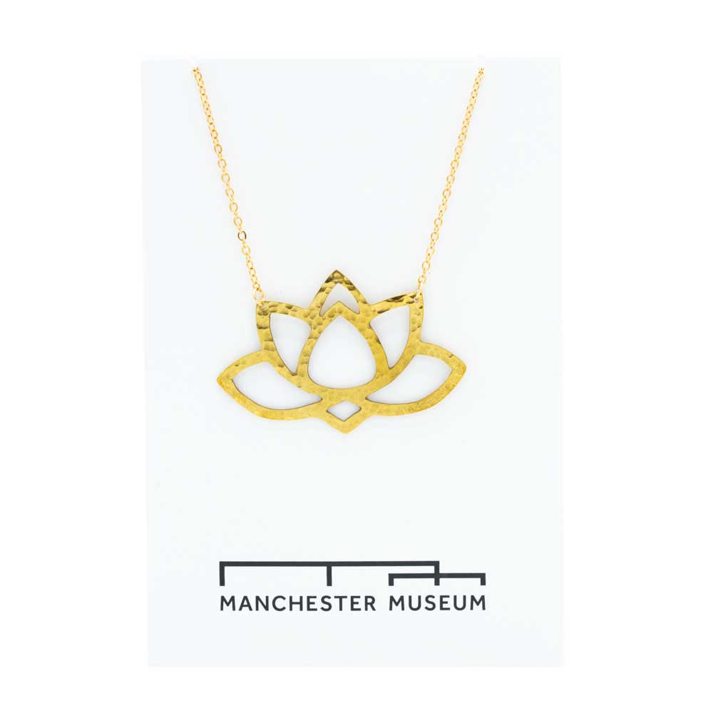 Brass lotus statement necklace draped over the museum branded white card that is part of the sustainable packaging.