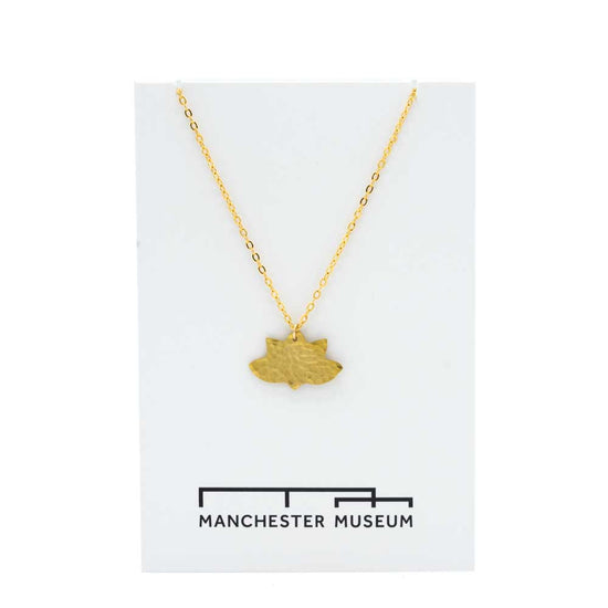 Lotus brass necklace draped over the museum bespoke white ard that is part of the sustainable packaging.