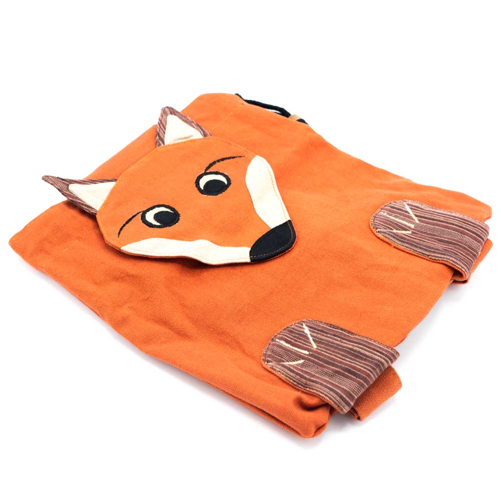 The red fox backpack with fox face shaped closure flap and little feet attached on the bottom. Angled side view.