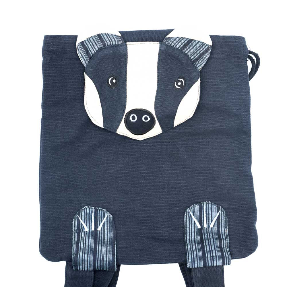 The black badger backpack with a badger face shaped closure flap and little feet attached on the bottom. Front view.