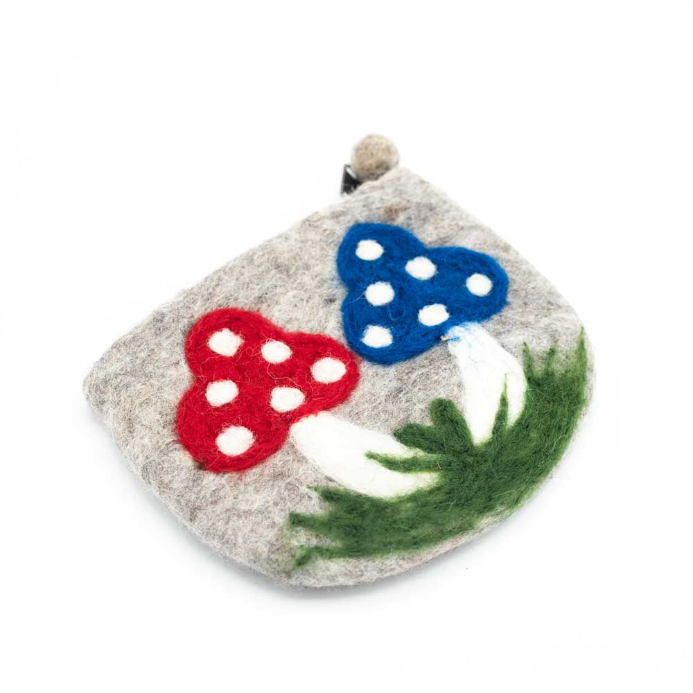 Grey felt purse with a curved bottom. Two mushrooms are growing from a dark green patch of grass in the bottom. One mushroom is red with white dots the other blue with white dots.