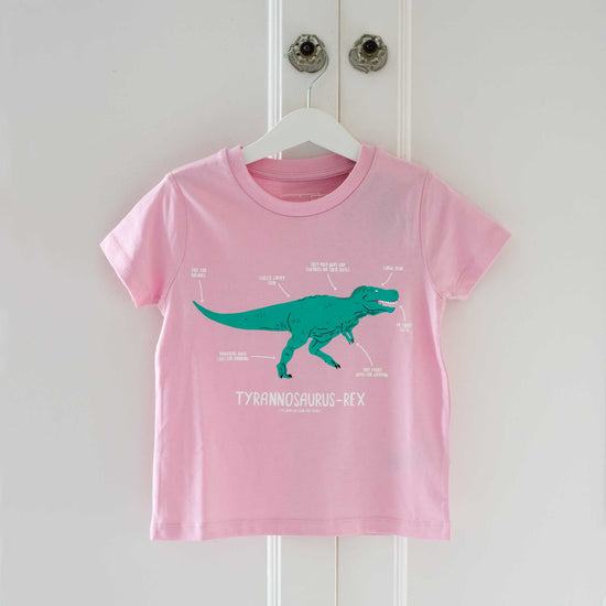 Load image into Gallery viewer, Pale pink shirt with a turquoise illustrated t-rex printed on the chest. Underneath the dinosaur the name and pronunciation are written in white.

