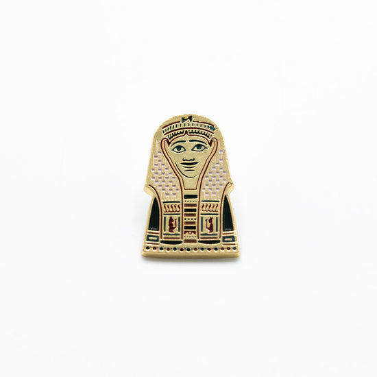 Golden pin with red engravings shown against a white background.