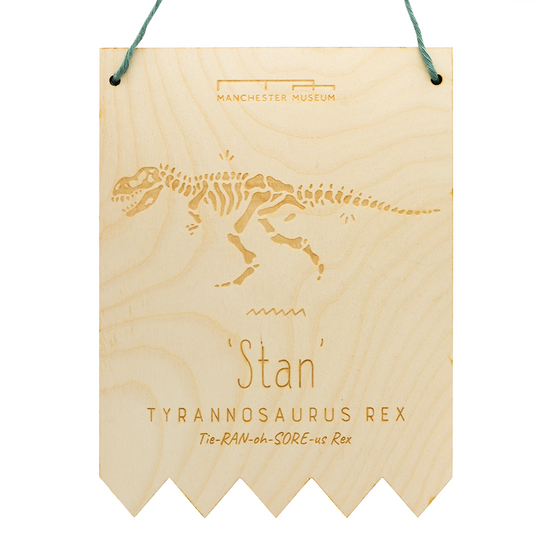 Image of a hanging wooden board against a white background. Engraving of Manchester Museum logo at the top. Tyrannosaurus Rex engraving at the centre.