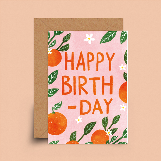 Pale pink card with orange citrus fruits and green leaves scattered. I orange-red large letters it says, happy birth-day.