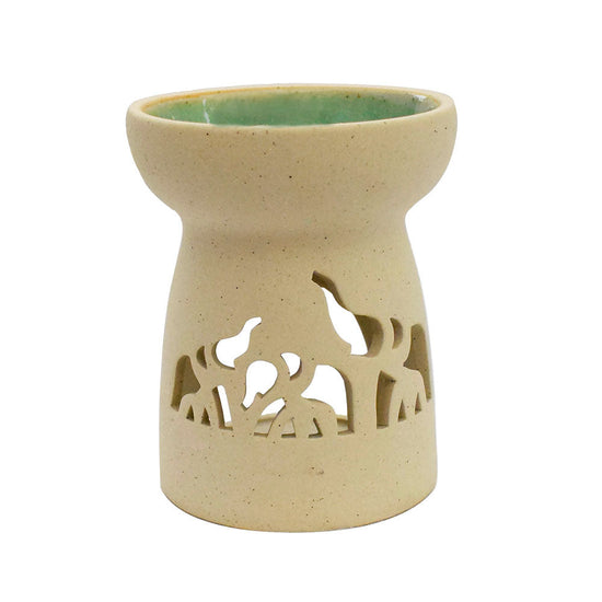 A white ceramic oil burner with elephant shapes cut out on the bottom half. The oil receptacle has a turquoise glaze.