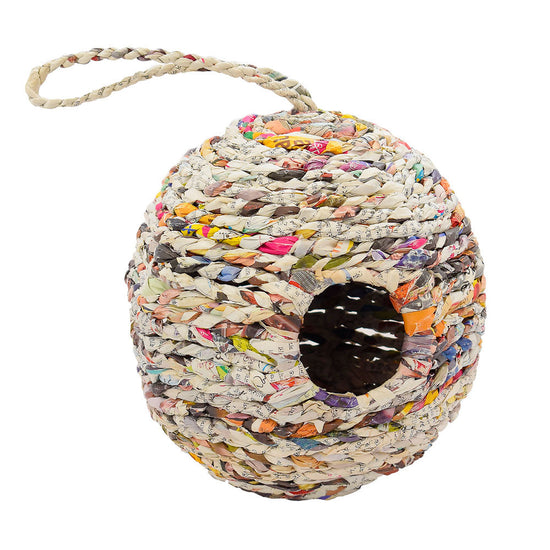 A round newspaper birdhouse with a small hole in front and newspaper string attached on the top for hanging.