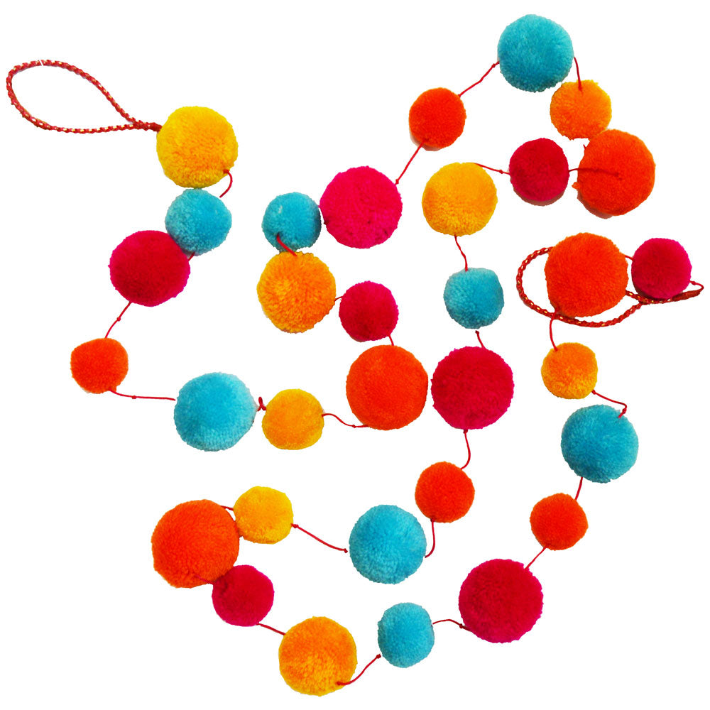 Pompom garland in bright colours on a white surface.